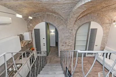 a staircase in a room with a brick wall at White flat Rione Monti in Rome