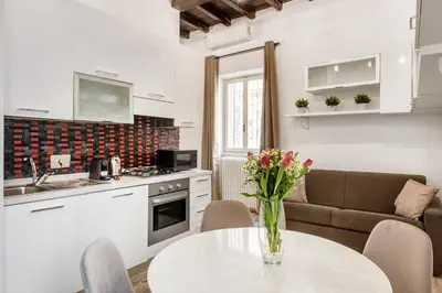 a kitchen and living room with a table and a couch at White flat Rione Monti in Rome