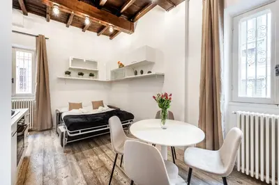 a room with a bed and a table and chairs at White flat Rione Monti in Rome