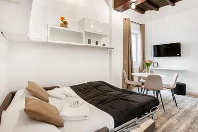 a bedroom with a large bed and a table at White flat Rione Monti in Rome