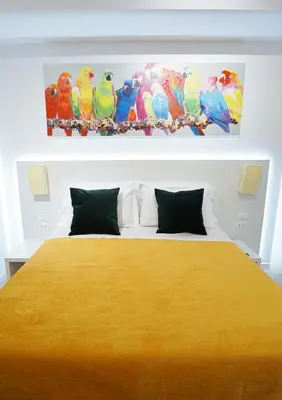 a bedroom with a yellow bed with birds on the wall at Duca's House in Rome