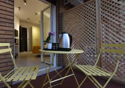 a table with a coffee pot on it next to two chairs at Duca's House in Rome