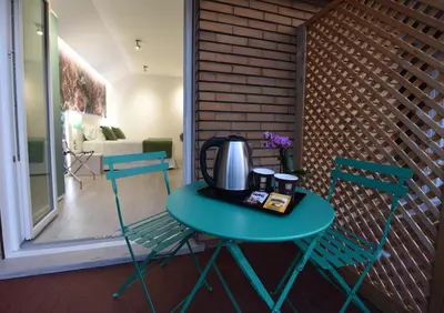 a table with a tea kettle on it next to two chairs at Duca's House in Rome