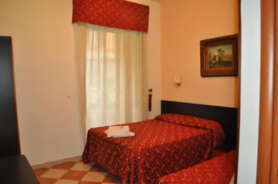 a hotel room with two beds and a window at B&B Sergio House in Rome