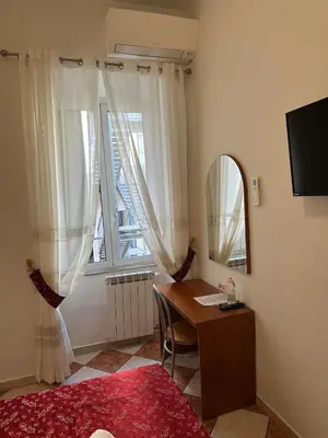 a bedroom with a desk and a mirror and a window at B&B Sergio House in Rome