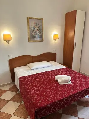 a bedroom with a large bed with a red blanket at B&B Sergio House in Rome