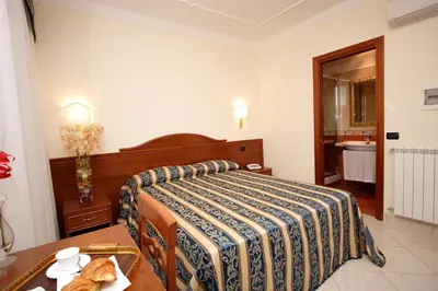 a bedroom with a bed and a table and a sink at Guest House Galaxy in Rome