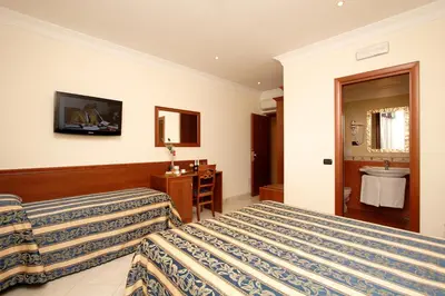 a hotel room with a bed and a tv on the wall at Guest House Galaxy in Rome