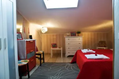 a bedroom with a red bed and a dresser at Alma de Roma in Rome