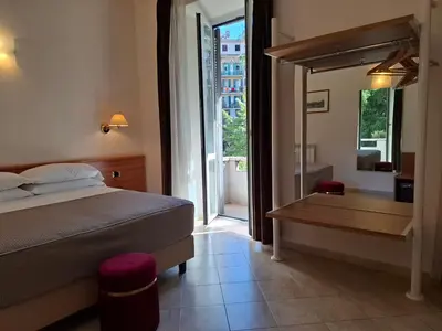 a bedroom with a bed and a table and a mirror at Hotel Principe Eugenio in Rome