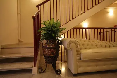 a plant in a vase next to a couch and stairs at Hotel Principe Eugenio in Rome