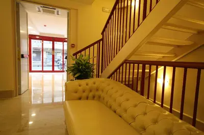 a couch in a living room with a staircase at Hotel Principe Eugenio in Rome