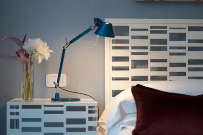 a blue lamp sitting on a table next to a bed at B&B Amor in Rome