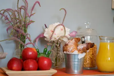 a table with apples and a bowl of bread and orange juice at B&B Amor in Rome