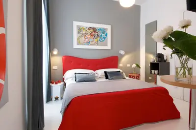 a bedroom with a red bed with two pillows on it at B&B Amor in Rome