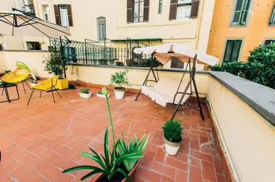 a patio with an umbrella and chairs and plants at La Vite Vaticana in Rome