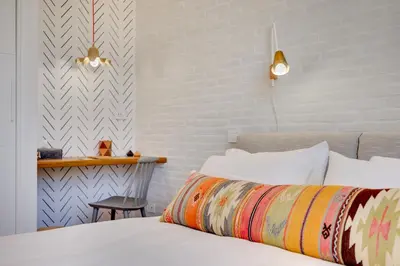 a bedroom with a white bed with a white brick wall at Beautiful designer apartment close to Pantheon in Rome
