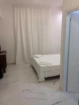 a white bedroom with a bed and a window at B&B Palombini in Rome