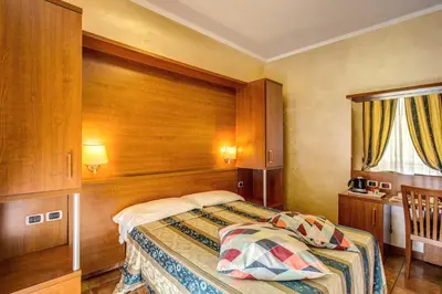 a bedroom with a bed with a wooden headboard at Hotel Maryelen in Rome
