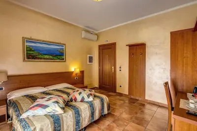 a hotel room with a bed and a table at Hotel Maryelen in Rome