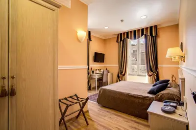 a hotel room with a bed and a desk and a window at PapavistaRelais in Rome