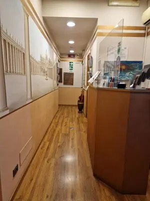 a hallway in a building with a reception counter at PapavistaRelais in Rome