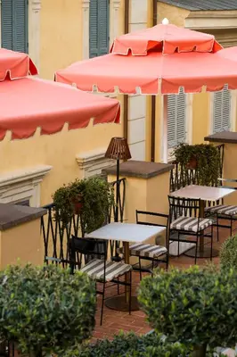 a group of tables and umbrellas on a patio at 9Hotel Cesari in Rome