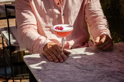a person holding a wine glass with a cocktail at 9Hotel Cesari in Rome