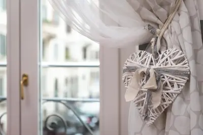 a white heart tied to a window with a curtain at Flaminia 36 Luxury Home in Rome