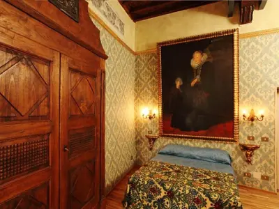 a bedroom with a bed and a painting on the wall at Antica Dimora dell'Orso in Rome