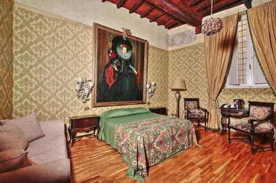 a bedroom with a painting of a woman on the wall at Antica Dimora dell'Orso in Rome