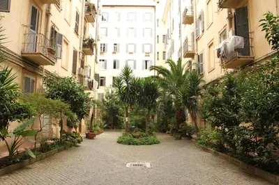 an empty courtyard with palm trees and buildings at Giovy in Rome