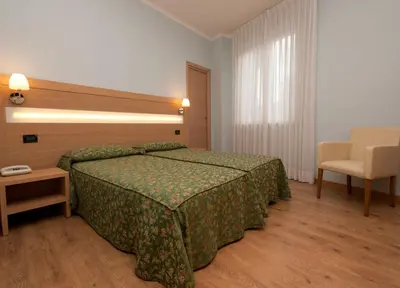 a hotel room with a bed and a chair at Hotel La Pergola in Rome