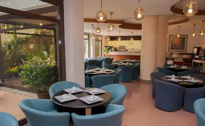 a dining room with tables and blue chairs at Hotel La Pergola in Rome