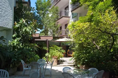 a courtyard with chairs and tables and trees at Hotel La Pergola in Rome