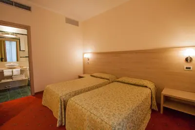 a hotel room with two beds and a bathroom at Hotel Laurentia in Rome
