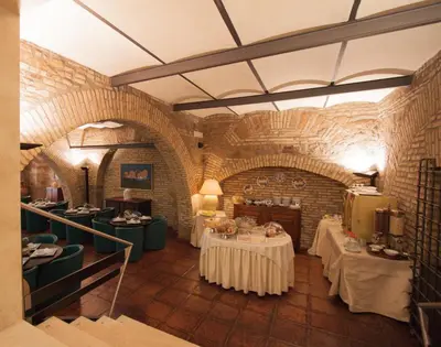 a dining room with two tables and a brick wall at Hotel Laurentia in Rome
