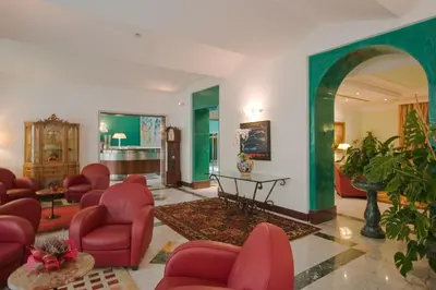 a living room with red chairs and a table at Ateneo Garden Palace in Rome