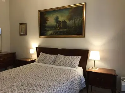 a bedroom with a bed and a painting on the wall at Nori Guest House in Rome