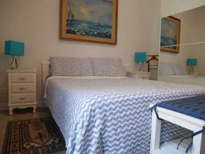 a bedroom with a bed with a blue and white blanket at Nori Guest House in Rome