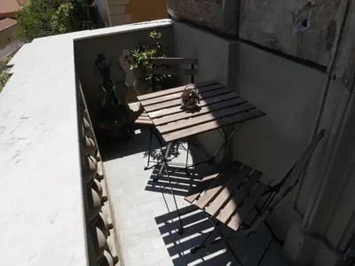 a wooden table and two chairs on a patio at Nori Guest House in Rome