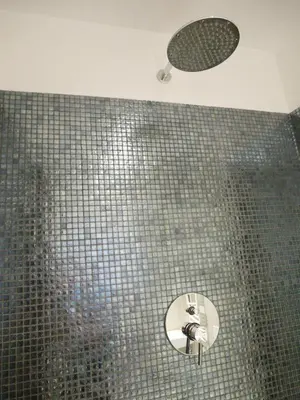 a bathroom with a shower with a tiled wall at Nori Guest House in Rome