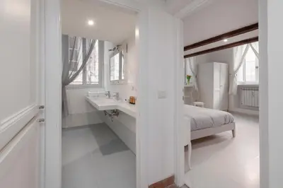 a white bathroom with a sink and a bed at Antique-Modern Flat by Navona Square in Rome