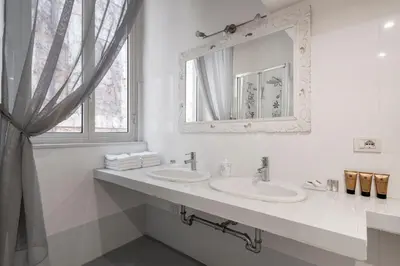 a white bathroom with two sinks and a mirror at Antique-Modern Flat by Navona Square in Rome