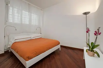 a bedroom with a bed with an orange blanket at Antique-Modern Flat by Navona Square in Rome