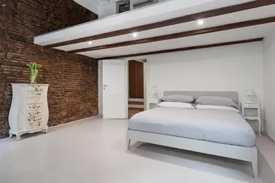 a bedroom with a white bed and a brick wall at Antique-Modern Flat by Navona Square in Rome