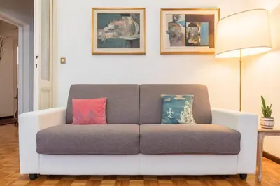 a couch in a living room with two pillows on it at Flower's Market Apartment - Charme Holidays in Rome