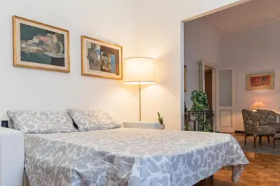 a bedroom with a white bed and a chair at Flower's Market Apartment - Charme Holidays in Rome