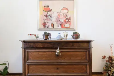 a wooden dresser in a room with a painting on the wall at Flower's Market Apartment - Charme Holidays in Rome