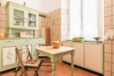 a kitchen with a table with a bowl of fruit on it at Flower's Market Apartment - Charme Holidays in Rome